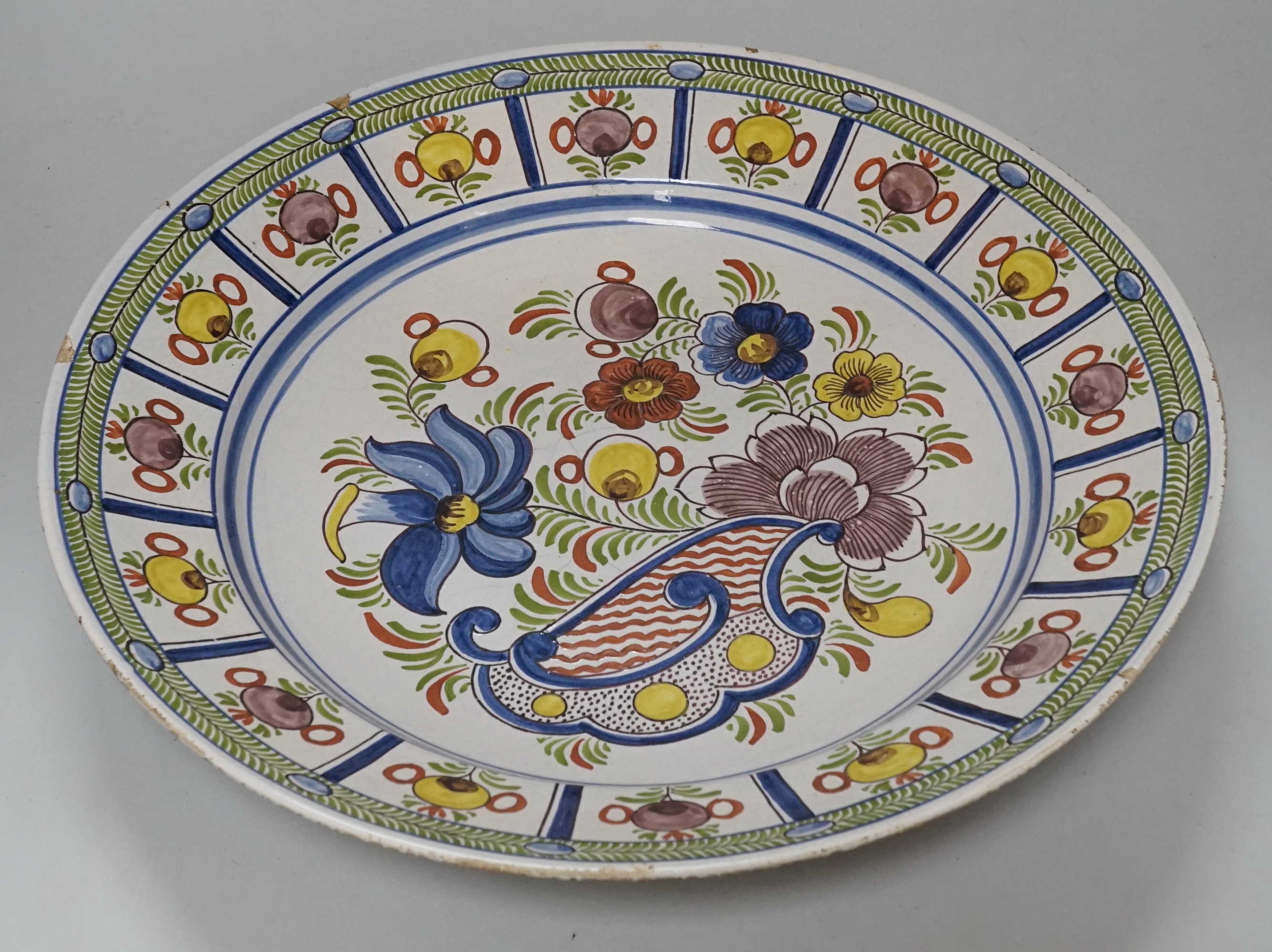 An 18th century Delft polychrome charger, 35cm diameter